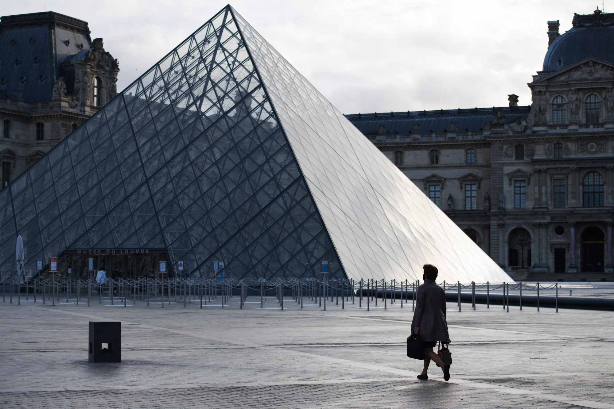 A pedestrian crosses the empty courtyard outside Louvre Museum during morning rush hour in Paris, France, on&nbsp;Nov. 2.&nbsp;