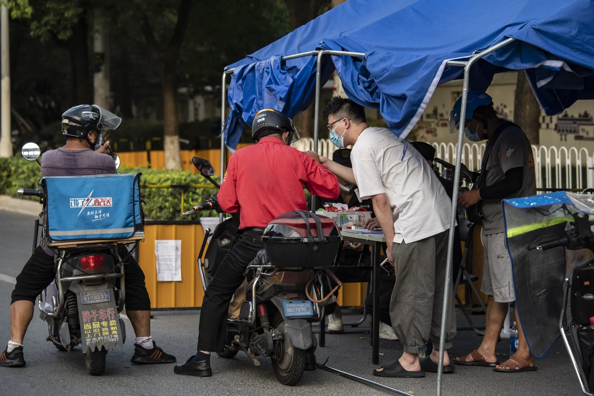 Delivery drivers pass through a security checkpoint as several city blocks are sealed off due to Covid-19 in the Meilong township of Shanghai, China, on&nbsp;Aug. 15.