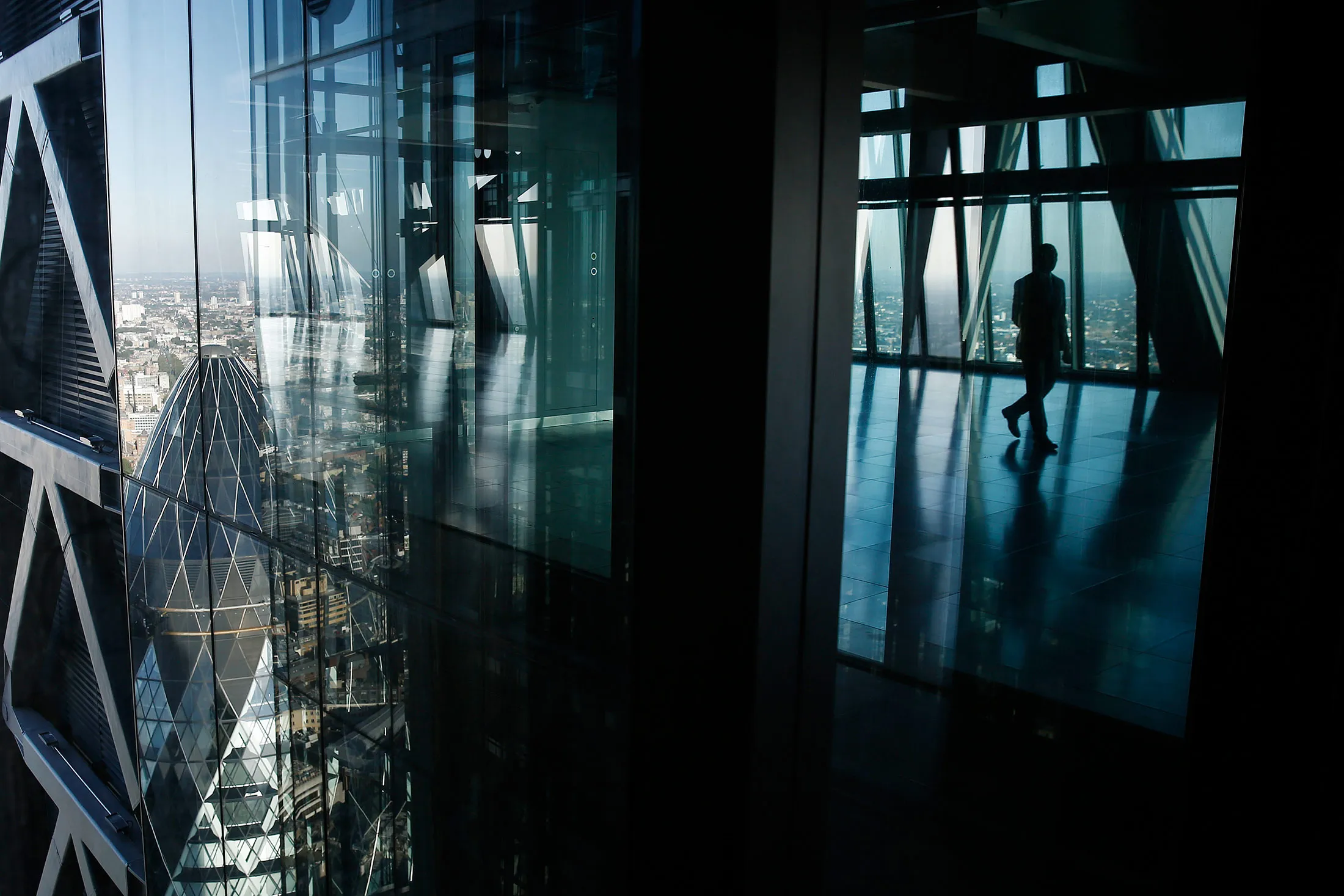 The glass windows of the Leadenhall Building, also known as the Cheesegrater, reflect the neighboring skyscraper at 30 St Mary Axe, also known as the Gherkin, left, in the financial district of London.
