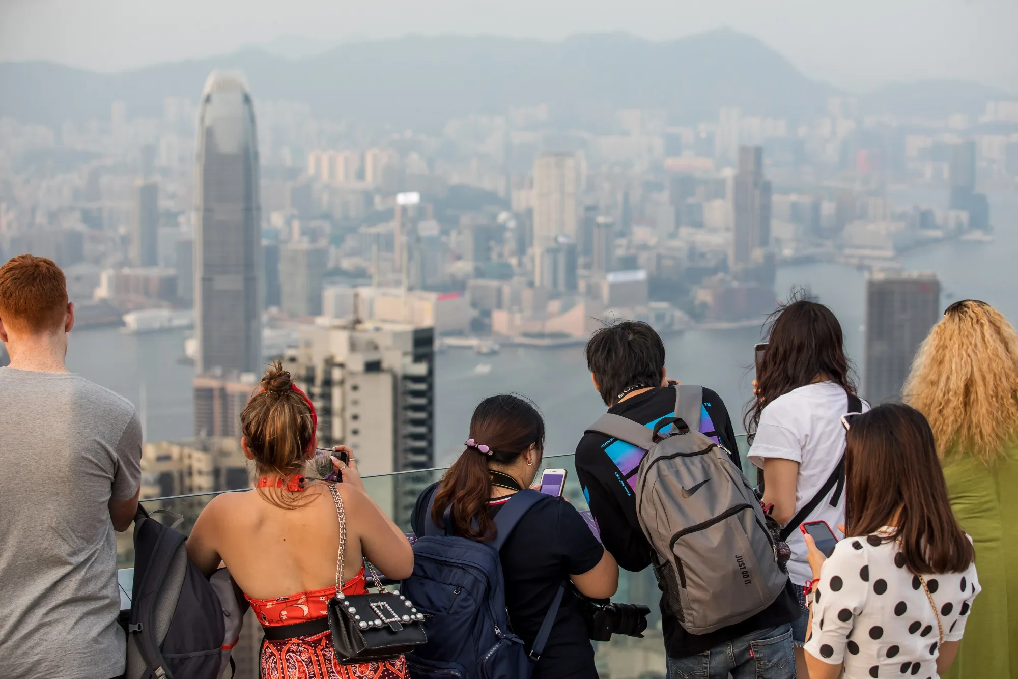 Tourists look at the city's skyline from a viewing terrace on Victoria Peak in Hong Kong.