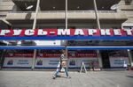 A pedestrian passes a Russian supermarket, branded in the colors of the Russian Federation, in Limassol.