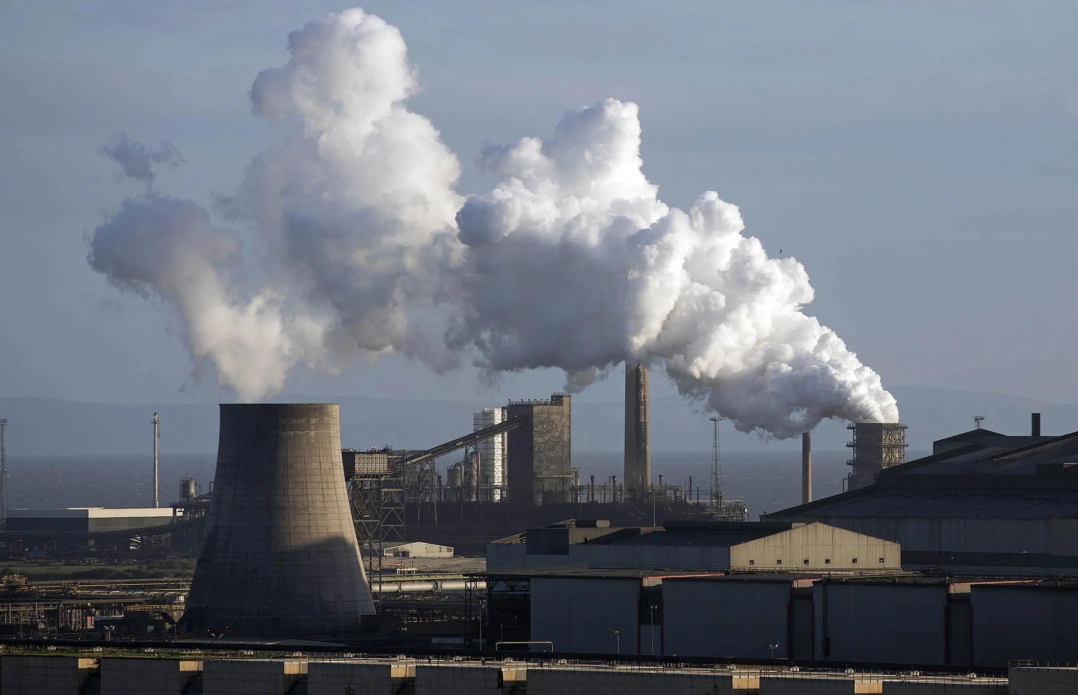 Vapor rises from cooling towers at the steel works operated by Tata Steel in Port Talbot, U.K.
