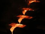 Molten gold cools as it runs from a furnace into bar molds during casting at the Kibali gold mine in the Democratic Republic of Congo.
