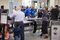 A TSA official helps passengers load their carry-on belongings onto an automated conveyer belt at a newly designed passenger screening lane unveiled at Hartsfield-Jackson Atlanta International Airport on May 25.