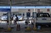 Drivers sit on stools while BYD Co. E6 electric taxis sit charging at a charging station in Taiyuan, Shanxi province, China.