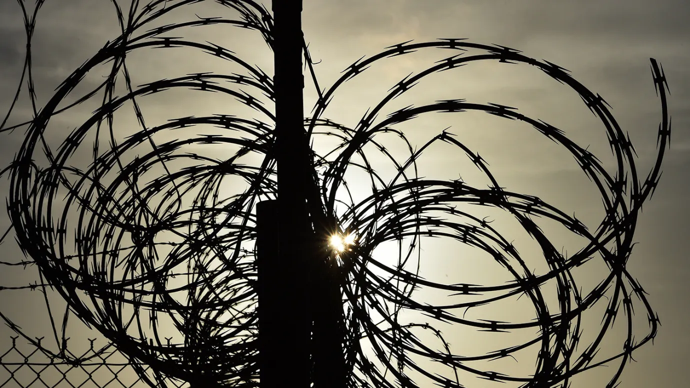 This photo made during an escorted visit and reviewed by the US military, shows the razor wire-topped fence at the abandoned 'Camp X-Ray' detention facility at the US Naval Station in Guantanamo Bay, Cuba, April 9, 2014.
