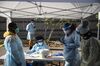 Healthcare workers wear personal protective equipment (PPE) as they wait to register people at a Covid-19 testing facility outside the Hillcrest Recreational Center in Washington, D.C. on Nov. 24.