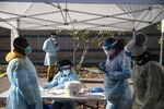 Healthcare workers wear personal protective equipment (PPE) as they wait to register people at a Covid-19 testing facility outside the Hillcrest Recreational Center in Washington, D.C. on Nov. 24.