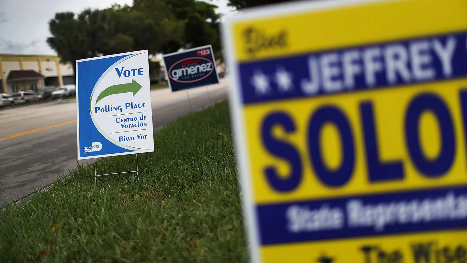 A sign shows the way to the polling place as people vote in the Florida primary on Aug. 30, 2016, in Miami.
