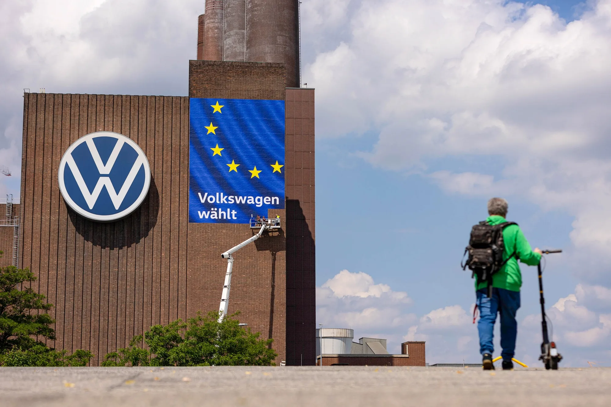 Workers install a European Union election campaign poster at the Volkswagen AG factory in Wolfsburg, Germany, in May.
