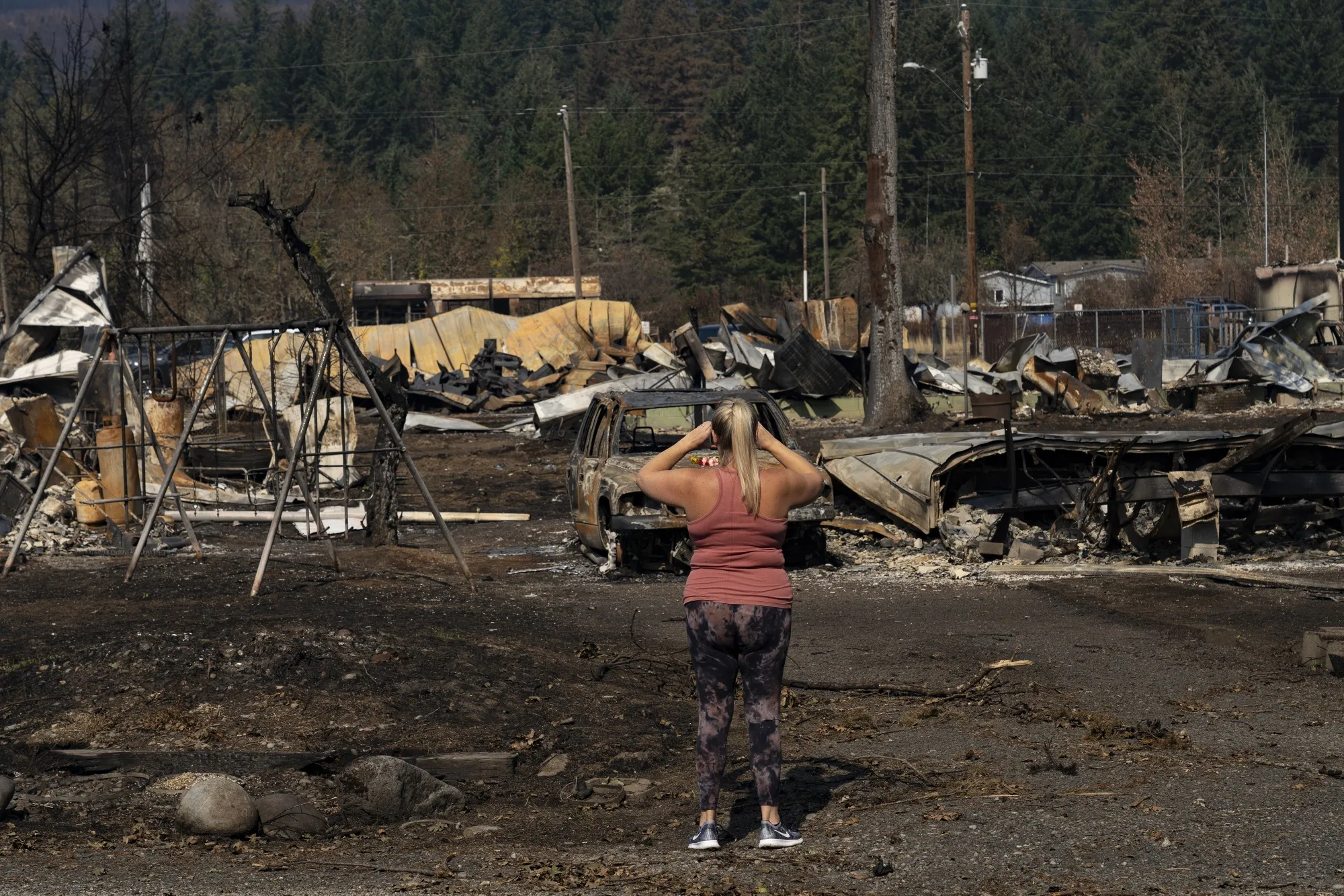 A woman takes a photo&nbsp;of properties and vehicles destroyed by the wildfires in Gates, Oregon, in September 2020.