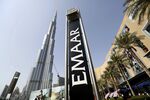 An Emaar Properties PJSC sign stands beside billboards promoting the Opera district developments near the Burj Khalifa tower in Dubai, United Arab Emirates.