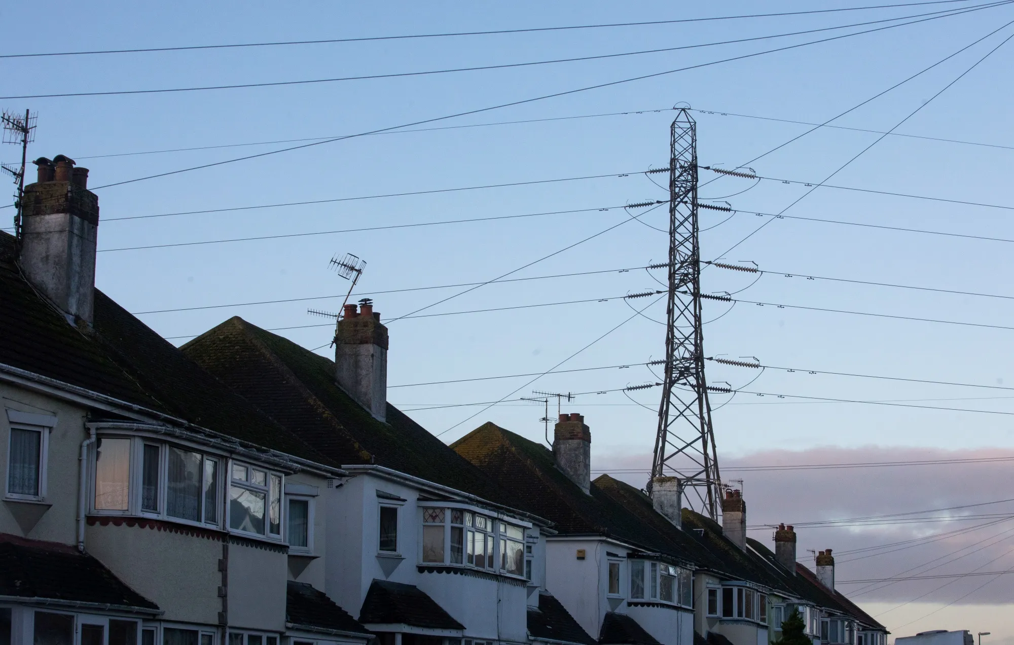 An electricity transmission pylon above residential houses in Brighton, U.K.