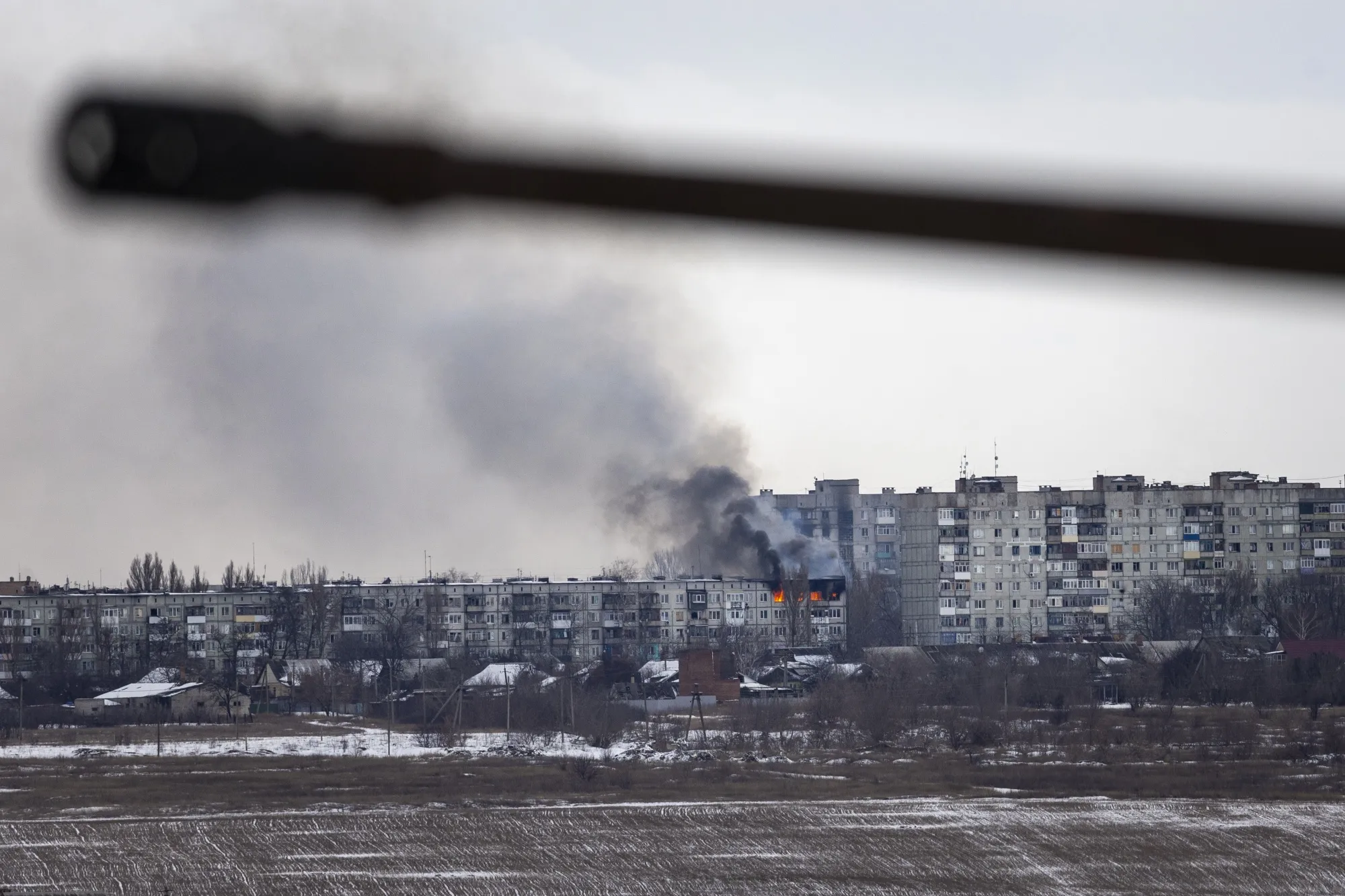 A Ukrainian military vehicle drives by an apartment building hit by Russian artillery in Bakhmut, Ukraine on February 14.&nbsp;