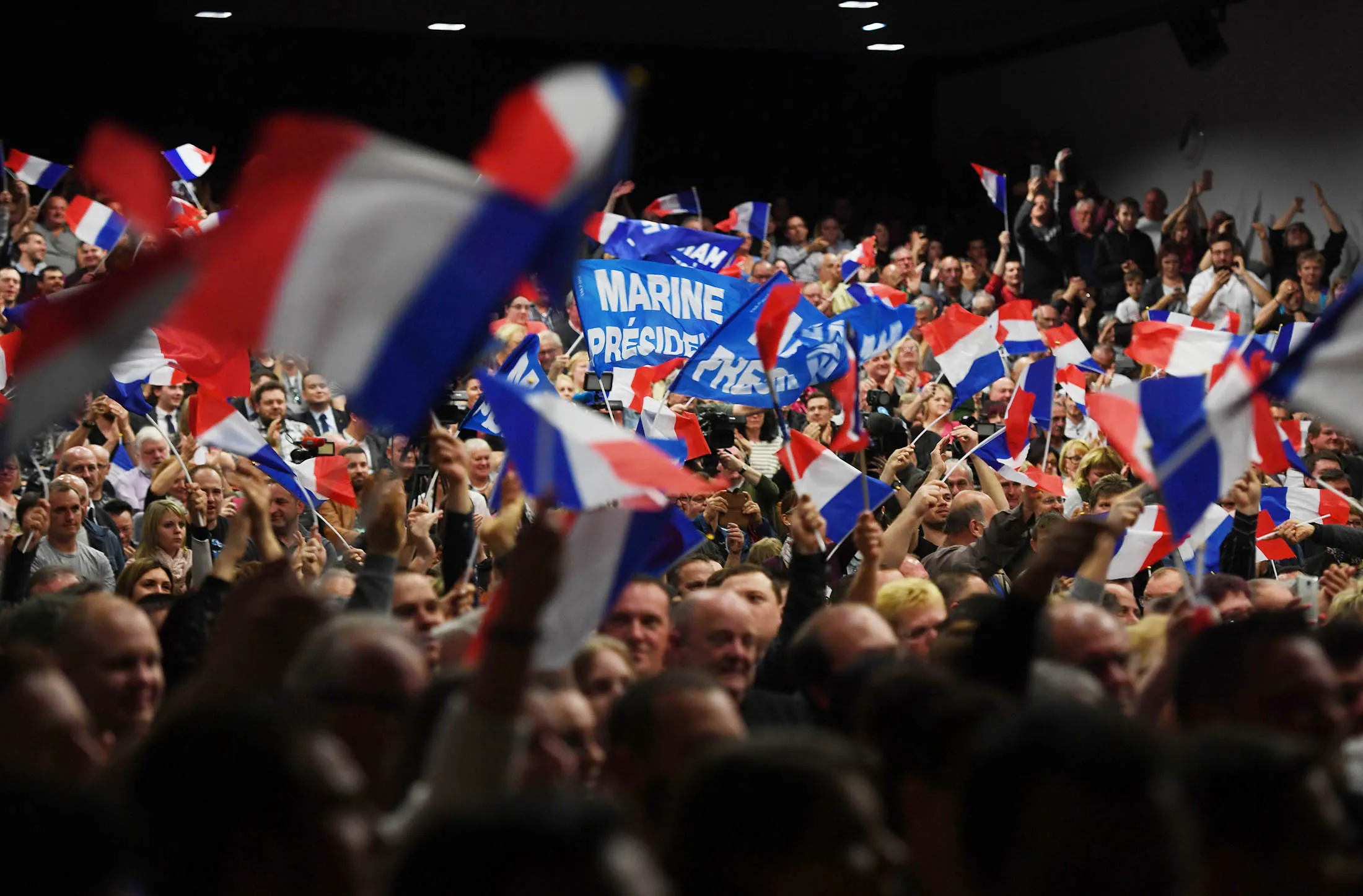 Supporters wave French flags during a rally of French presidential election candidate for the far-right Front National (FN) party Marine Le Pen, in Monswiller, north-eastern France, on April 5, 2017. / AFP PHOTO / ALAIN JOCARD (Photo credit should read ALAIN JOCARD/AFP/Getty Images)
