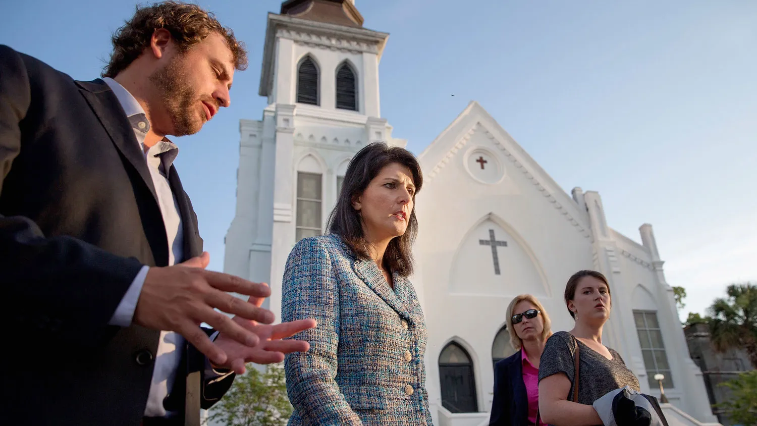 Escorted by staff and security, South Carolina Governor Nikki Haley (C) moves from one television interview to another across from the historic Emanuel African Methodist Episcopal Church June 19, 2015 in Charleston, South Carolina.
