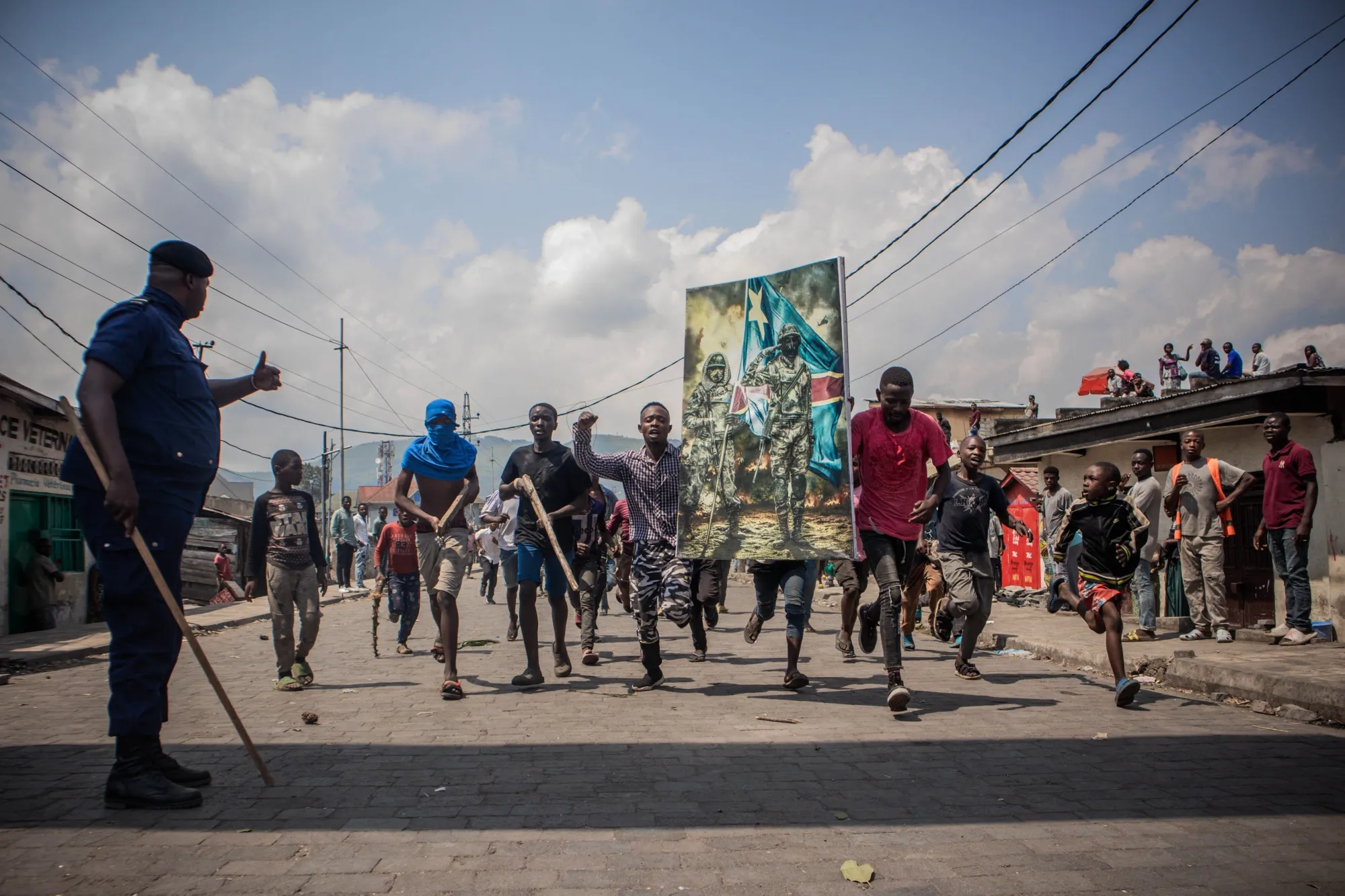 A policeman gives thumbs up as demonstrators carry a poster during a protest in Goma, Democratic Republic of the Congo on June 15.