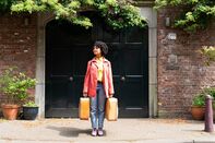 A young woman holding suitcases.