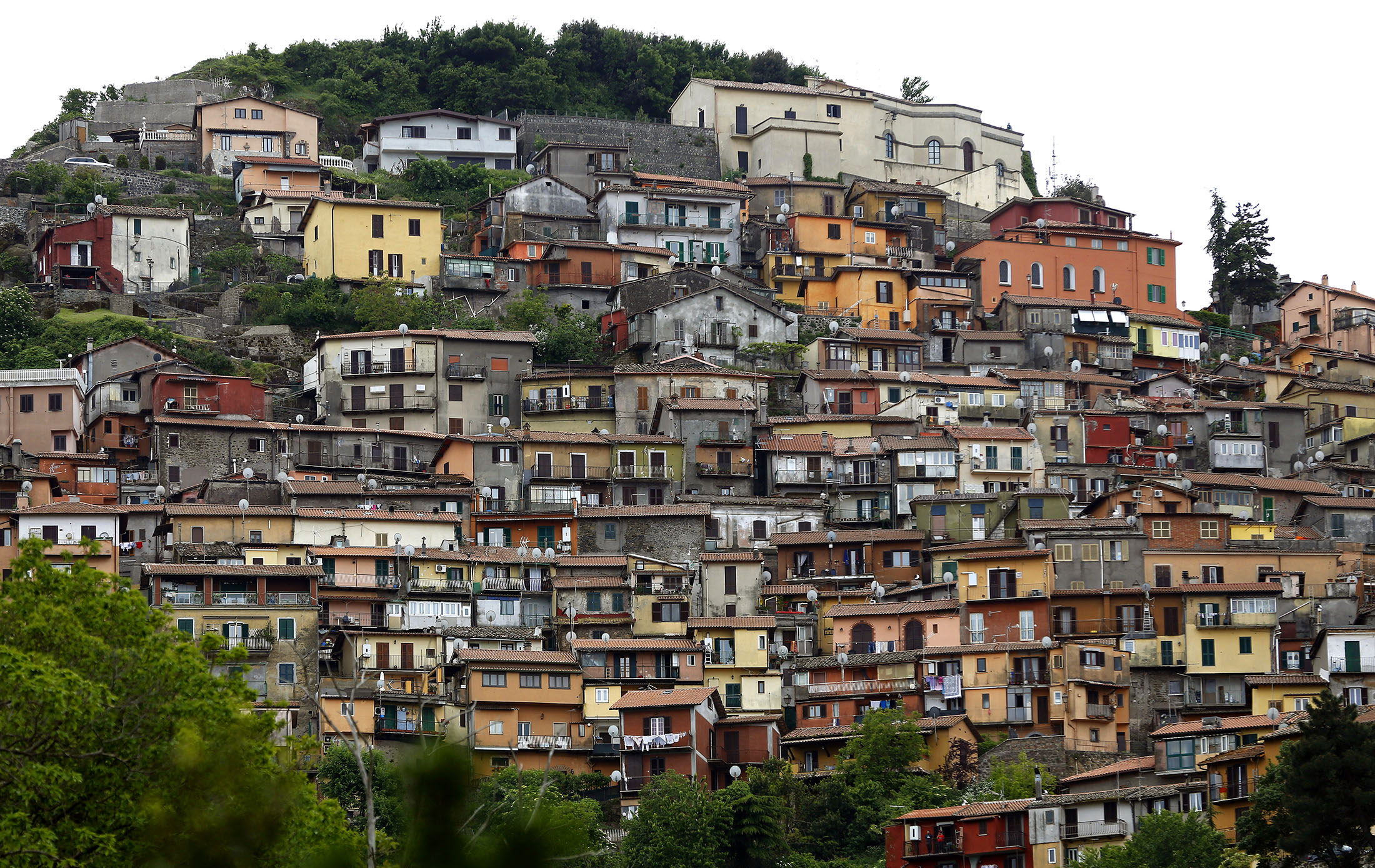 Traditional painted houses stand on a hillside in the town of Rocca di Papa, Italy.
