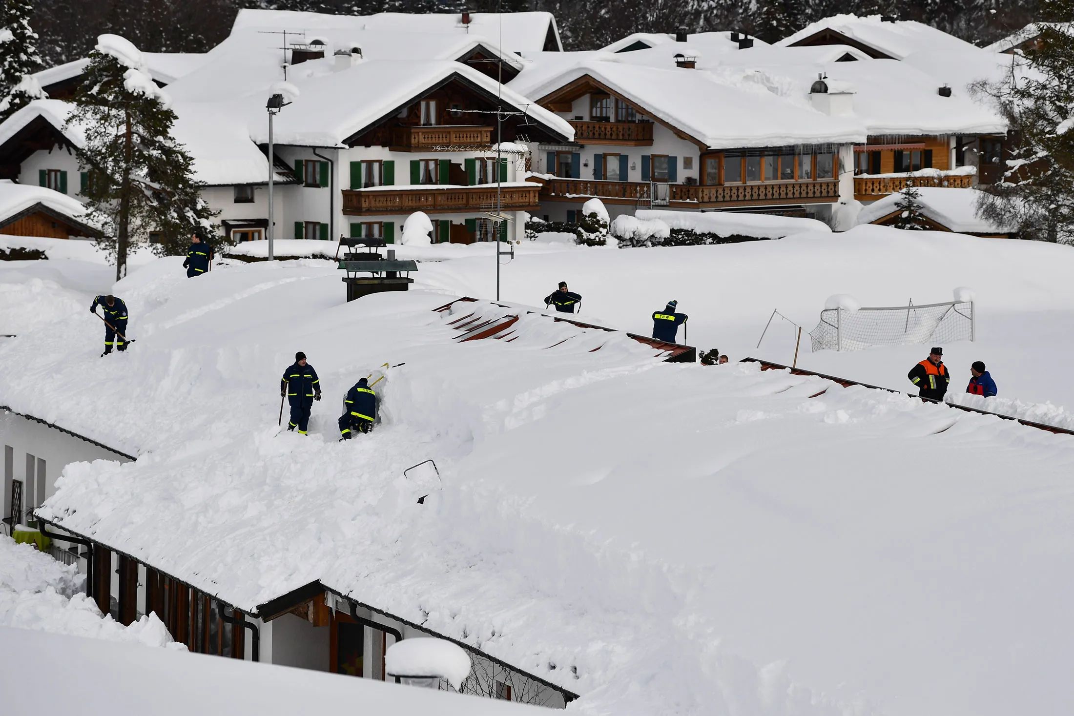 Rescue workers clear a roof following heavy snowfall in Kruen, Germany., near the Austrian border on Jan. 12.&nbsp;