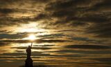 Sunrise Behind the Statue of Liberty in New York City