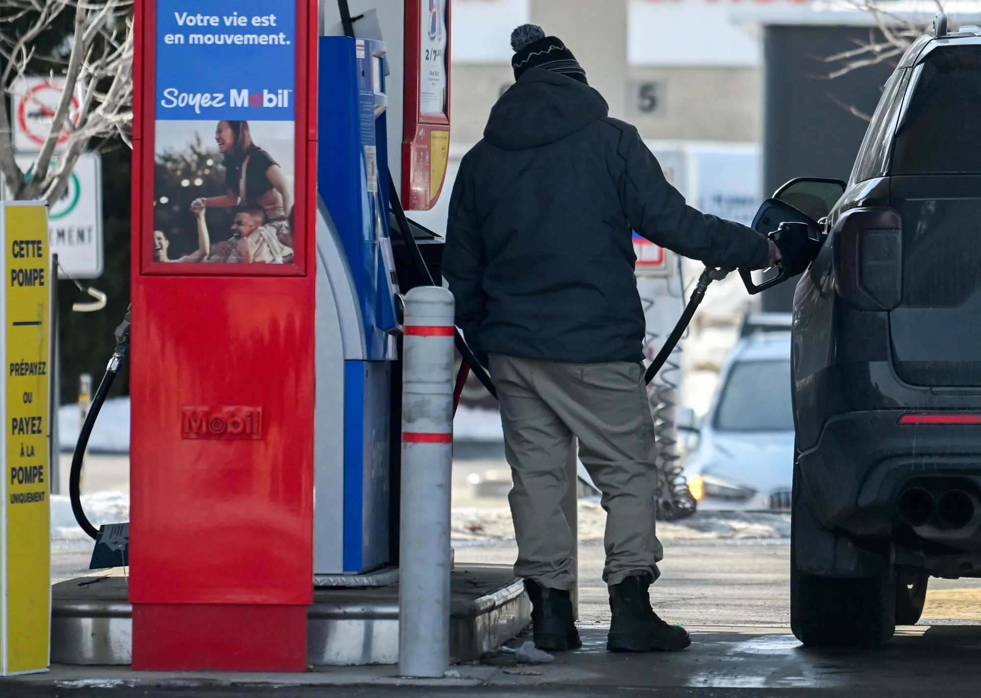 A driver refuels a vehicle at a Mobil gas station in Montreal.