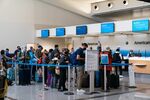 Travelers wait in line at the American Airlines check in counter at Hartsfield-Jackson Atlanta International Airport.