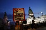 A demonstrator holds a sign during a protest against the International Monetary Fund (IMF) agreement as lawmakers vote on the bill outside the National Congress building in Buenos Aires, Argentina, on Thursday, March 17, 2022. 