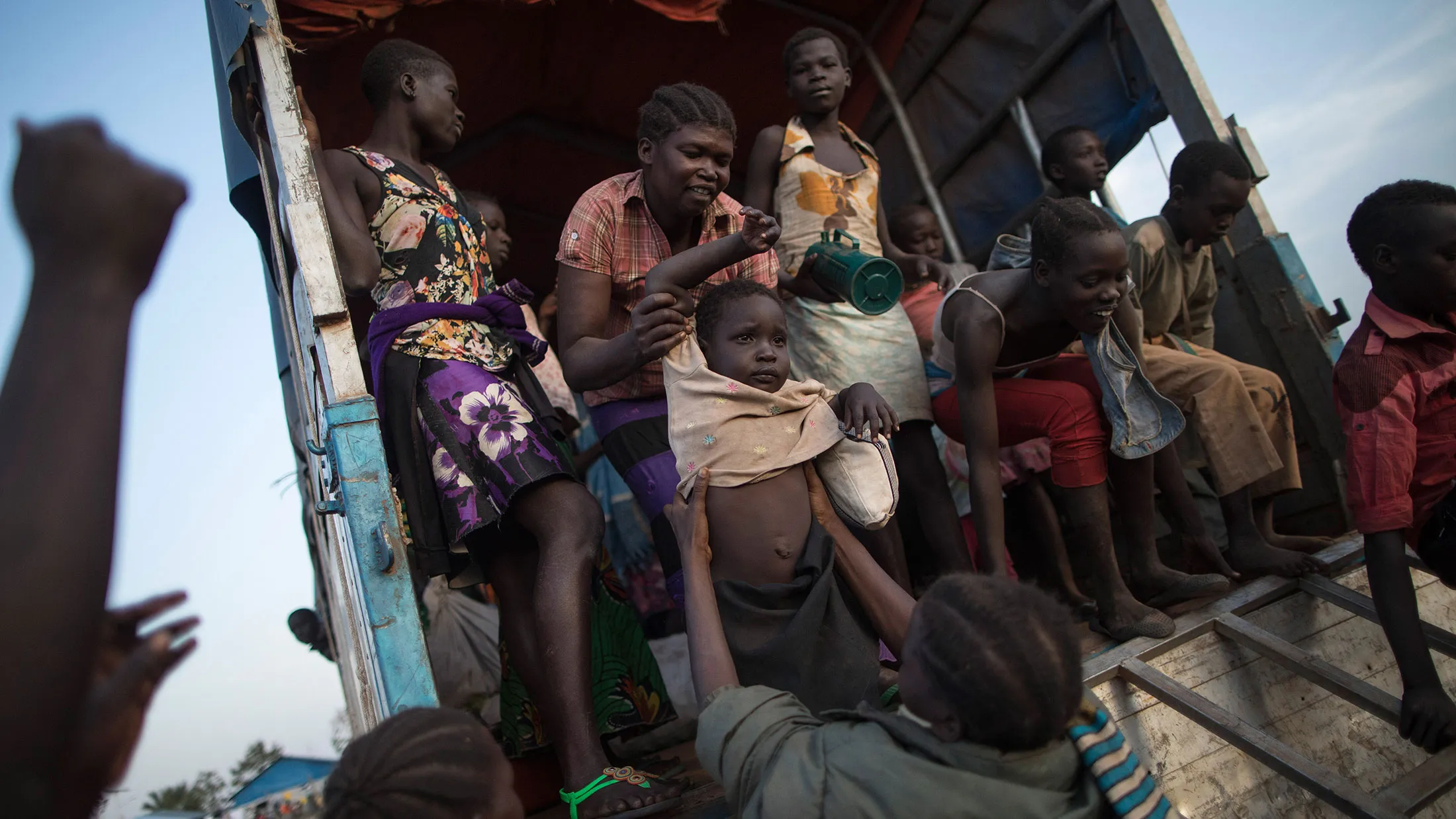 South Sudanese refugee families disembark a bus on Feb. 24, 2017, in Kuluba, Uganda.
