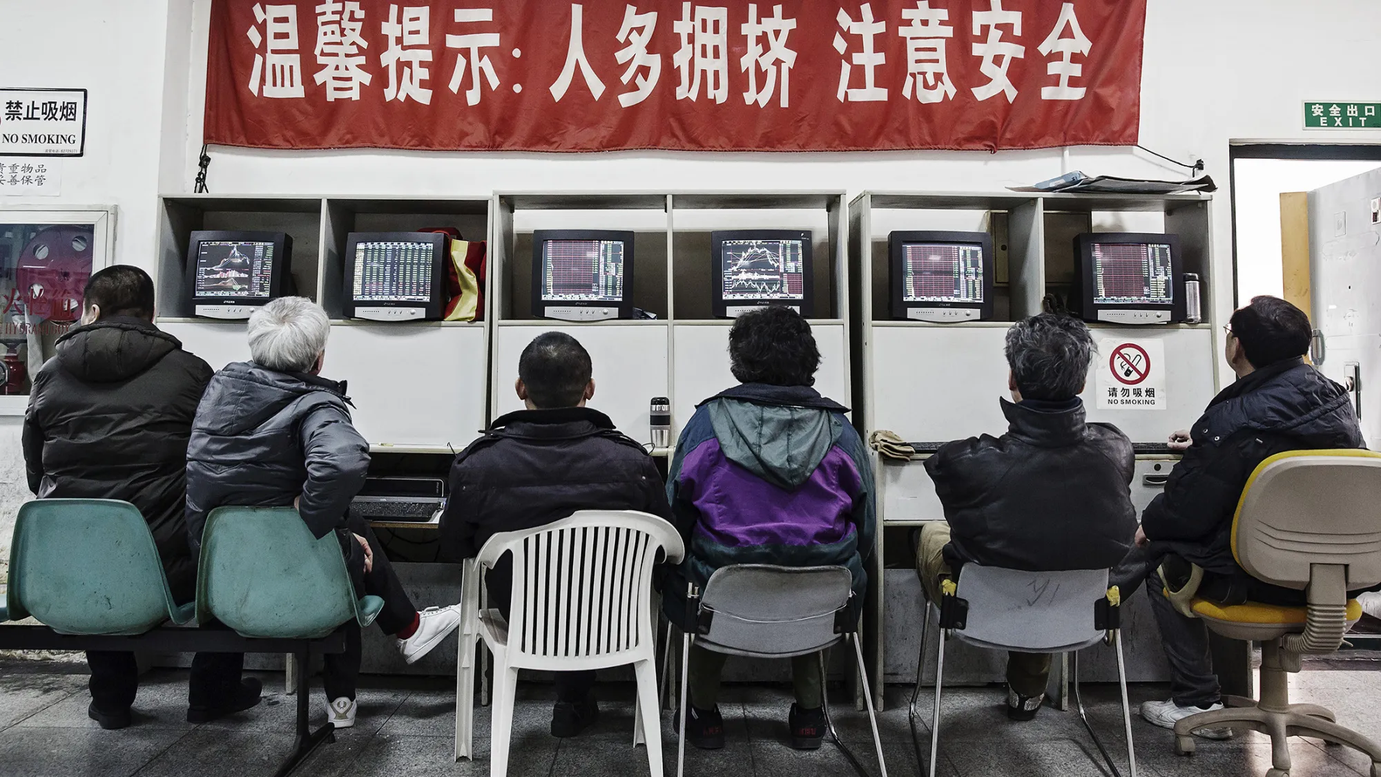 People sit at trading terminals at a securities exchange house in Shanghai, China, on Monday, Feb. 15, 2015. China's stocks fell as trading resumed after a week-long holiday which saw global equities enter a bear market on concern over the strength of the world economy.
