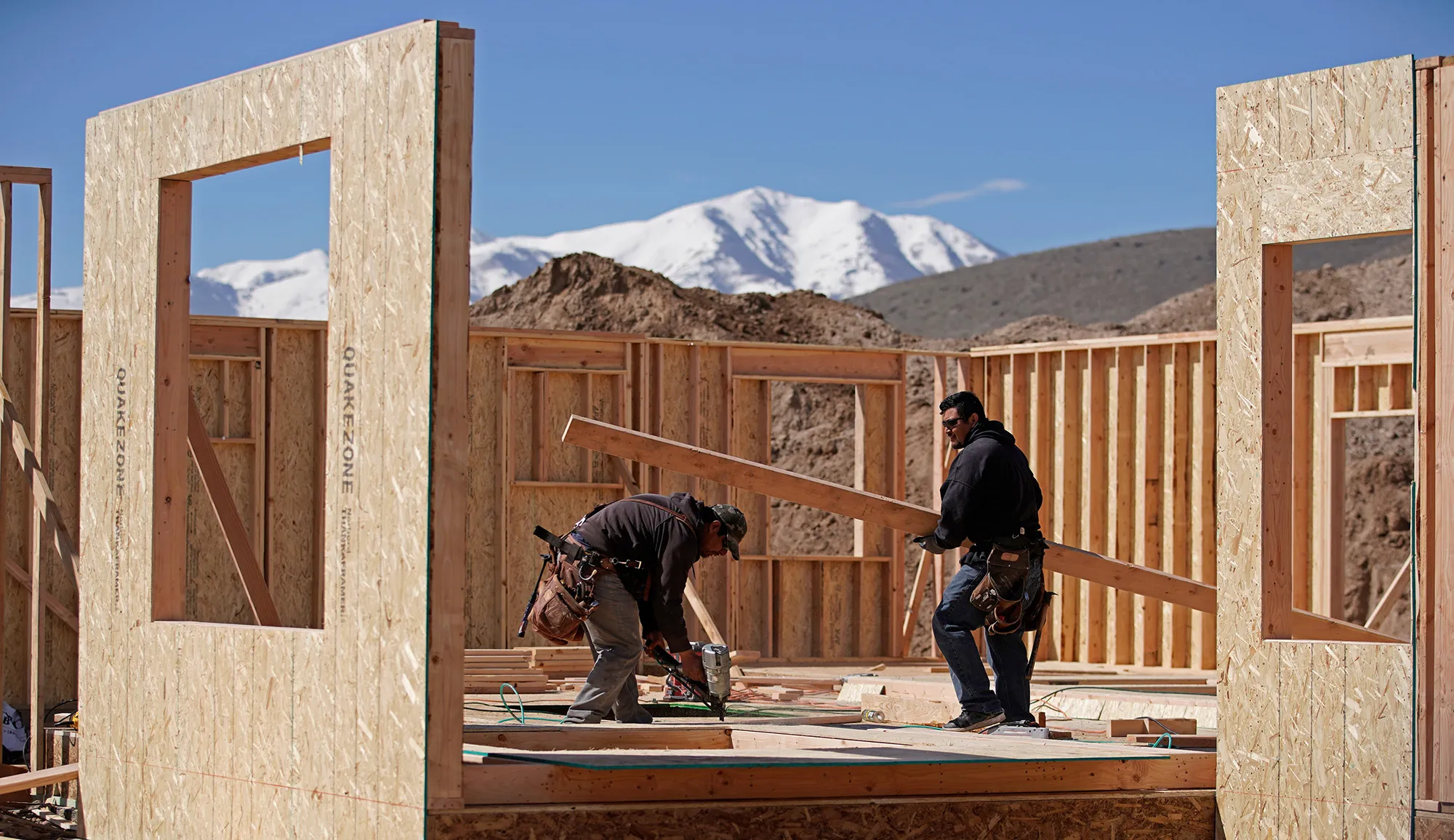 Workers build a floor at a home under construction in Saratoga Springs, Utah.