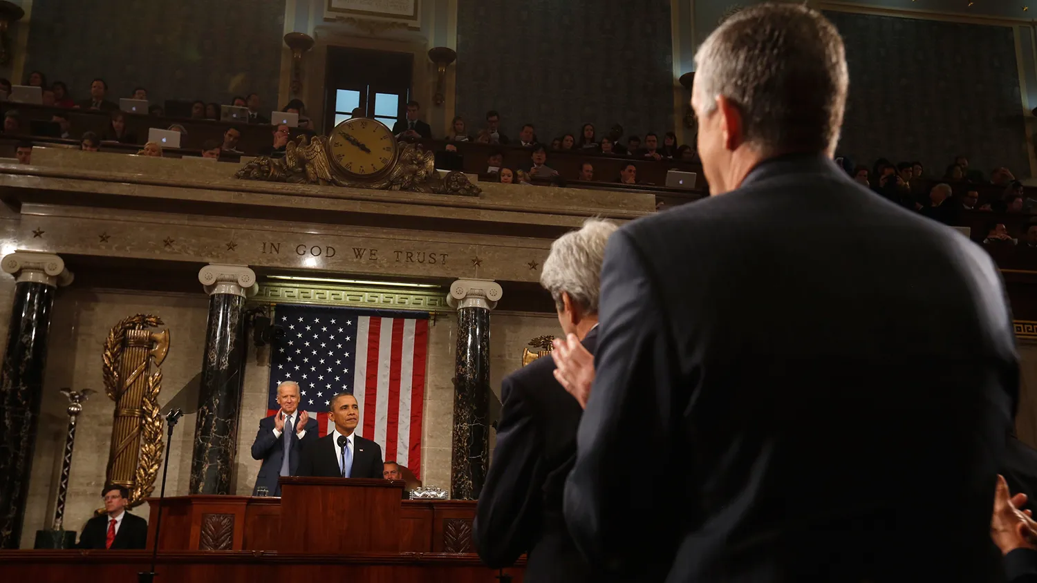 White House Chief of Staff Denis McDonough (R) and Secretary of State John Kerry (2nd R) applaud President Barack Obama as he delivers the State of the Union address at the US Capitol in Washington on January 28, 2014.
