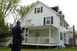 A Baltimore police officer stands in front of the home of the city's now-former mayor, Catherine Pugh, who has remained in seclusion as a corruption probe unfolded.