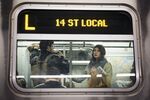 Passengers ride the L train during a morning commute. 
