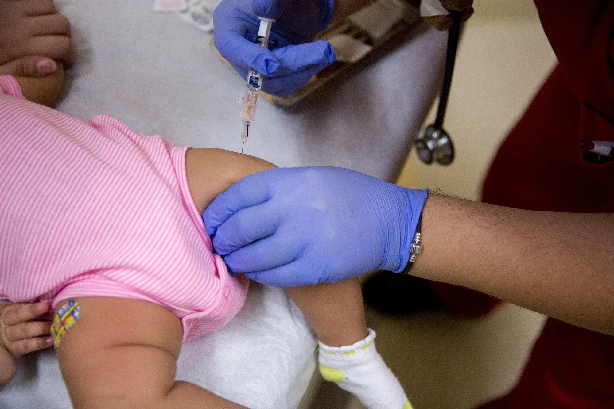 A medical assistant uses a syringe to administer a vaccine to an infant in Silver Spring, Maryland.