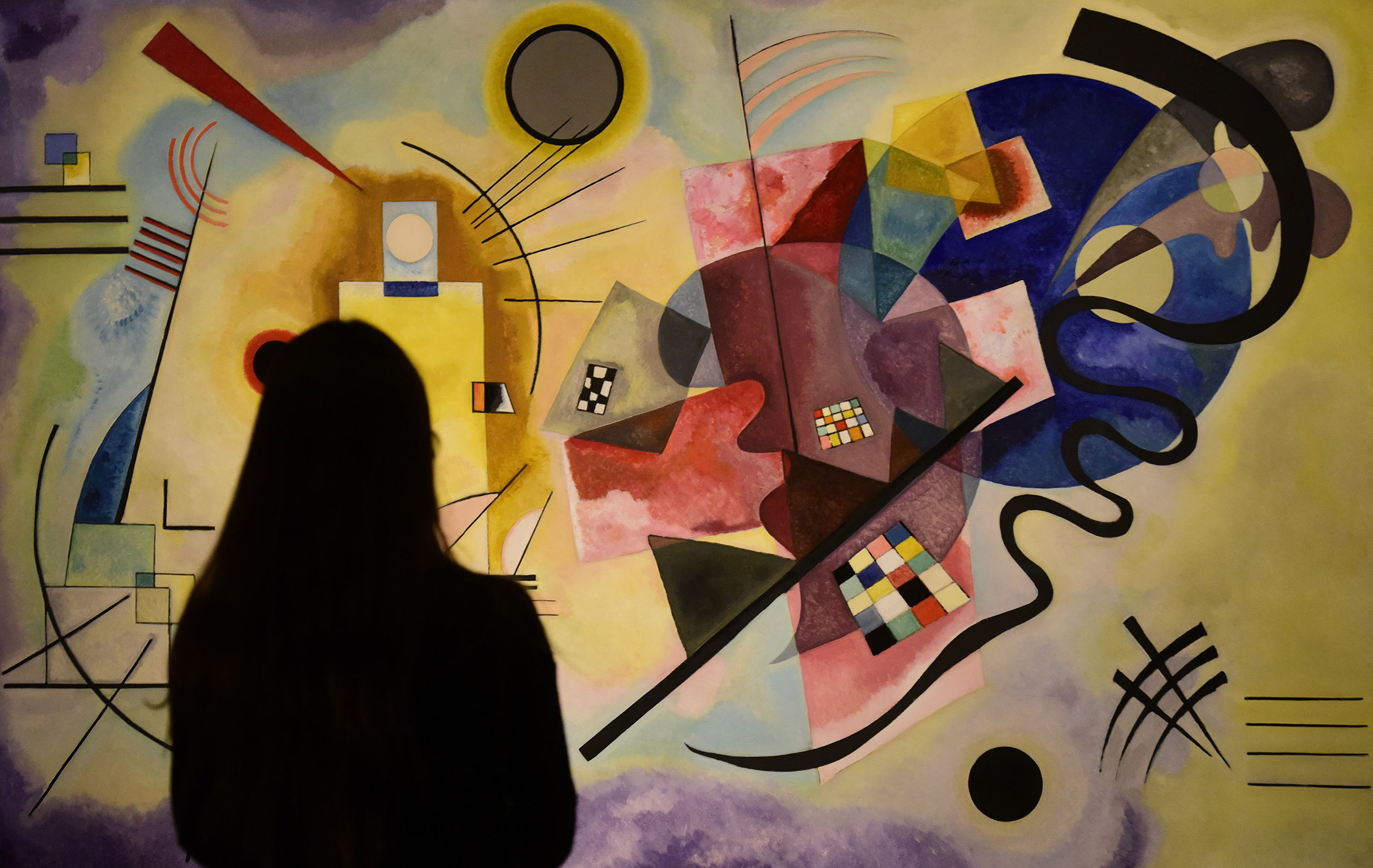A woman&nbsp;looks at a painting by&nbsp;Russian painter Wassily Kandinsky.