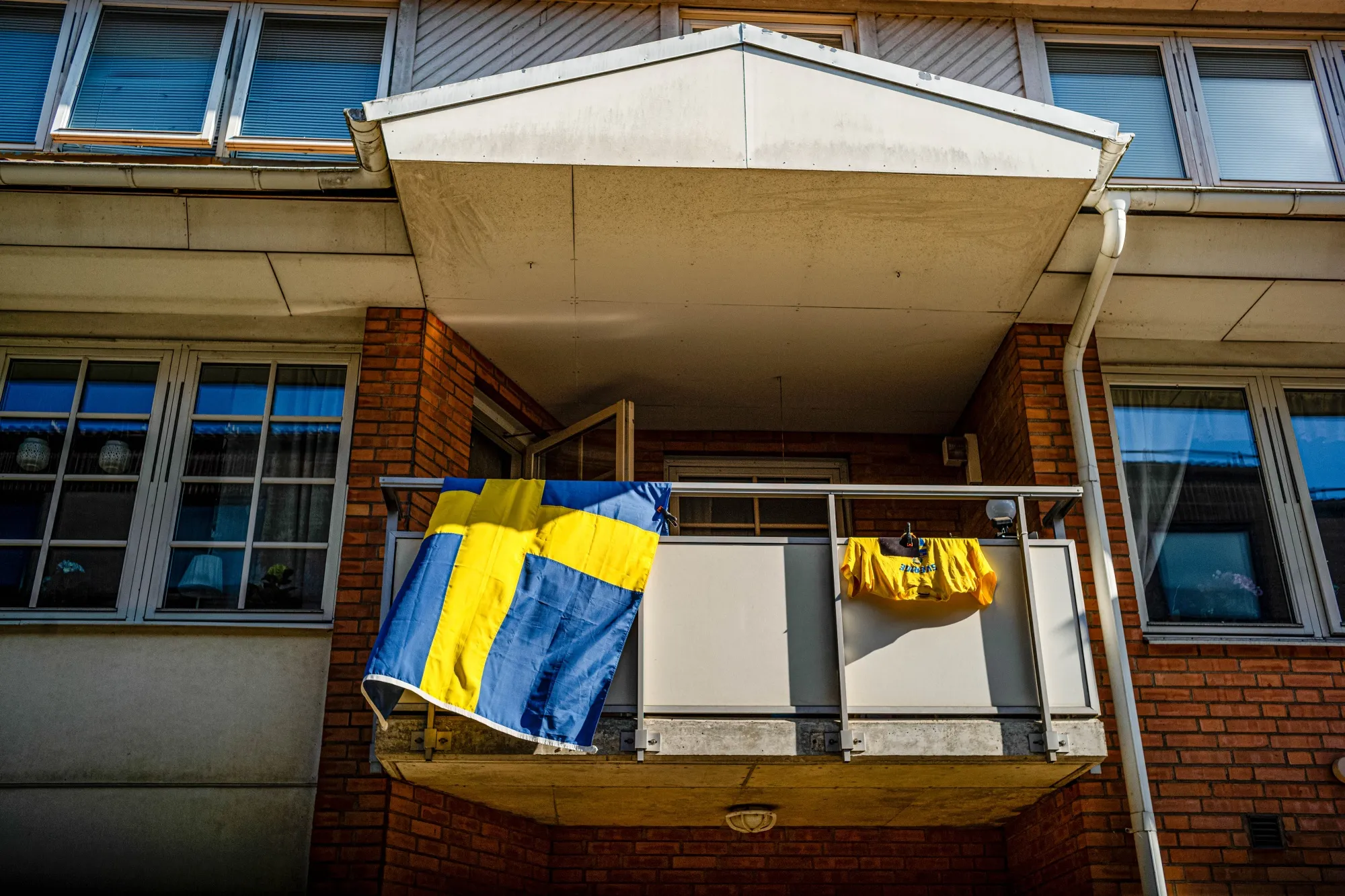 A Swedish national flag and national jersey on a balcony in Klippan.