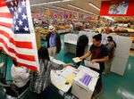 People vote in the U.S. presidential primary election at a polling station located in a grocery store, in National City, California, United States.