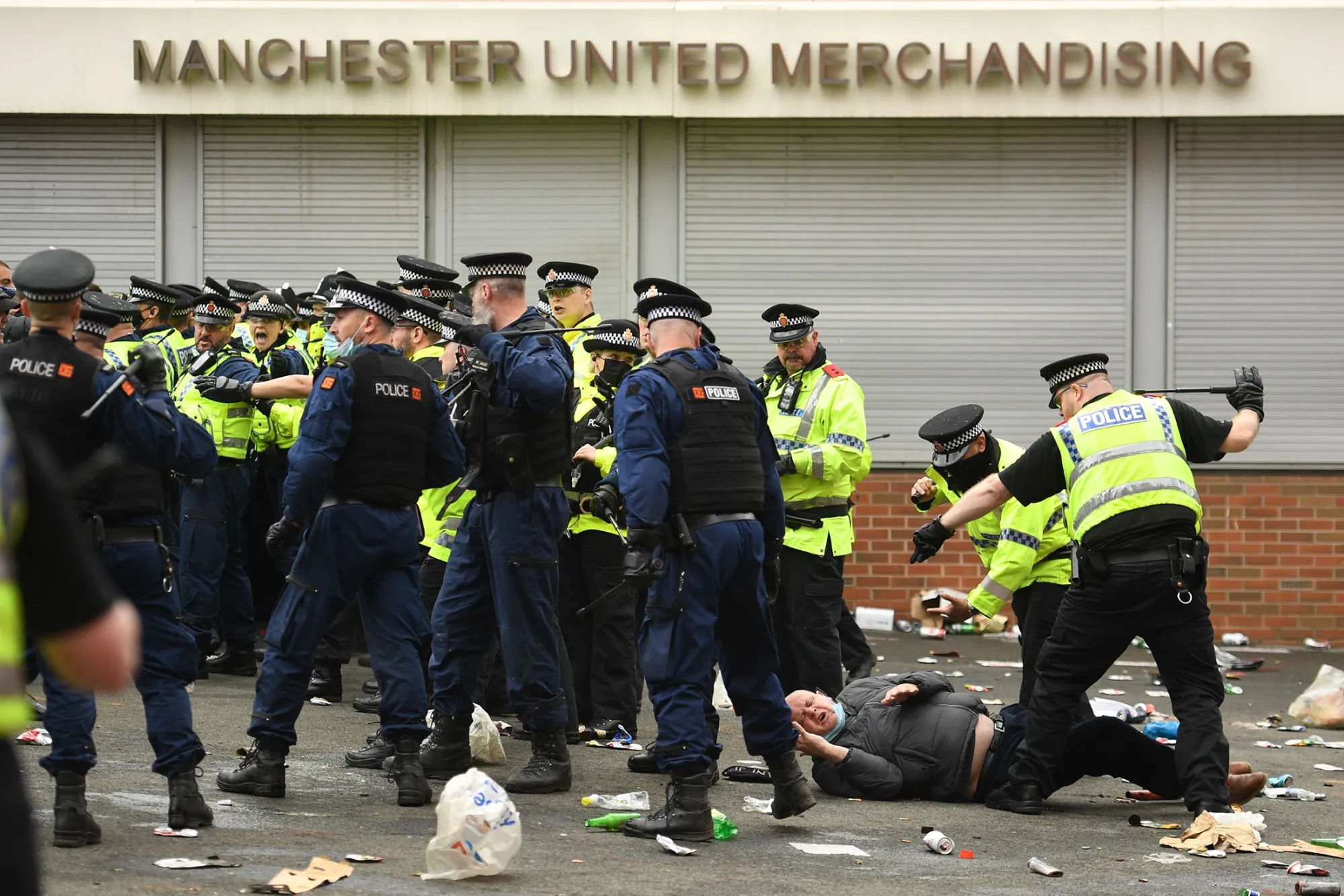 A protester falls as police move people away from the stadium after a demonstration against Manchester United's owners on May 2.