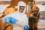 A technician wearing a full body protection suit pours material inside a biosafety level 3 Covid-19 research laboratory at the African Health Research Institute (AHRI) in Durban, South Africa, on Wednesday, Dec. 15, 2021.