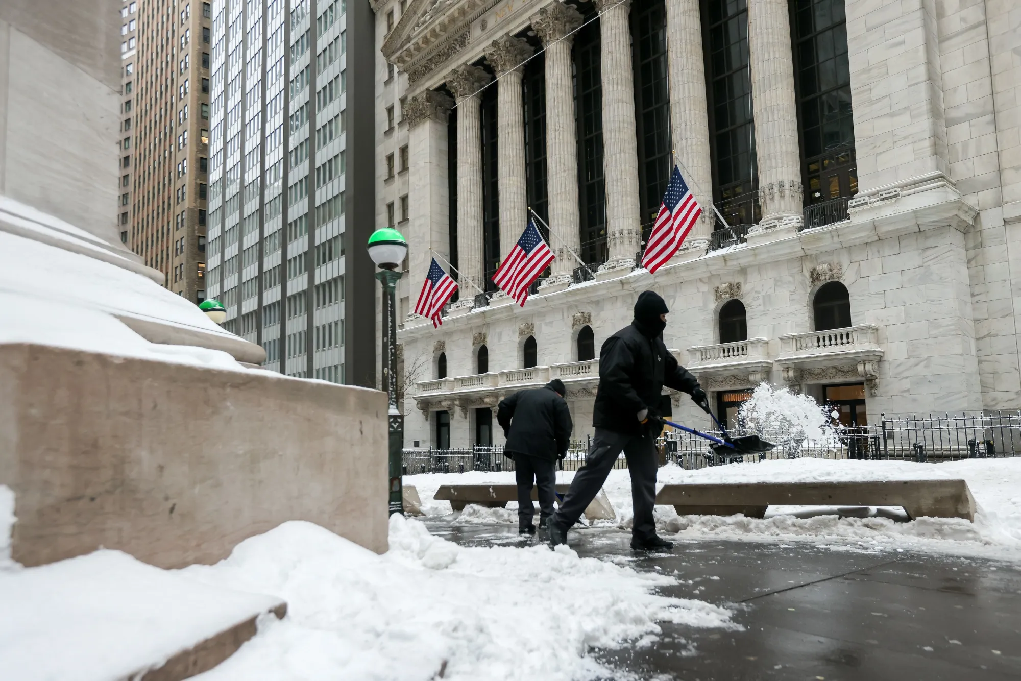 Các công nhân đang xúc tuyết trước Sở Giao dịch Chứng khoán New York.