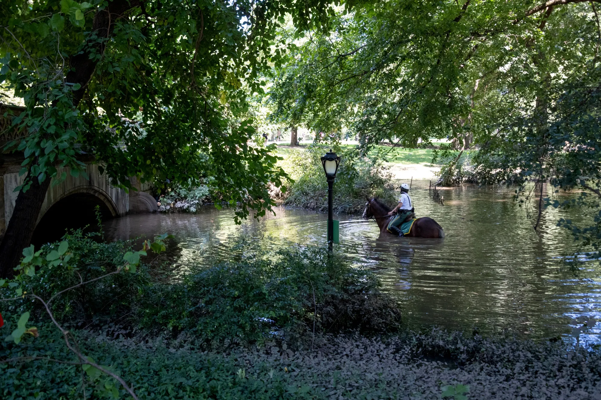 A New York City Parks officer&nbsp;on horseback explores the Greyshot Arch, which flooded in Central Park after rain from Hurricane Ida on Sept.&nbsp;2, 2021.&nbsp;