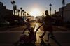 A woman and three children cross the street at sunset near storefronts by the pier in Manhattan Beach, California, U.S., on Sunday, Nov. 11, 2012. California faces a $1.9 billion spending gap through the end of the next fiscal year as revenue is projected to fall short of forecasts and spending exceeds estimates, the state’s independent fiscal analyst said.