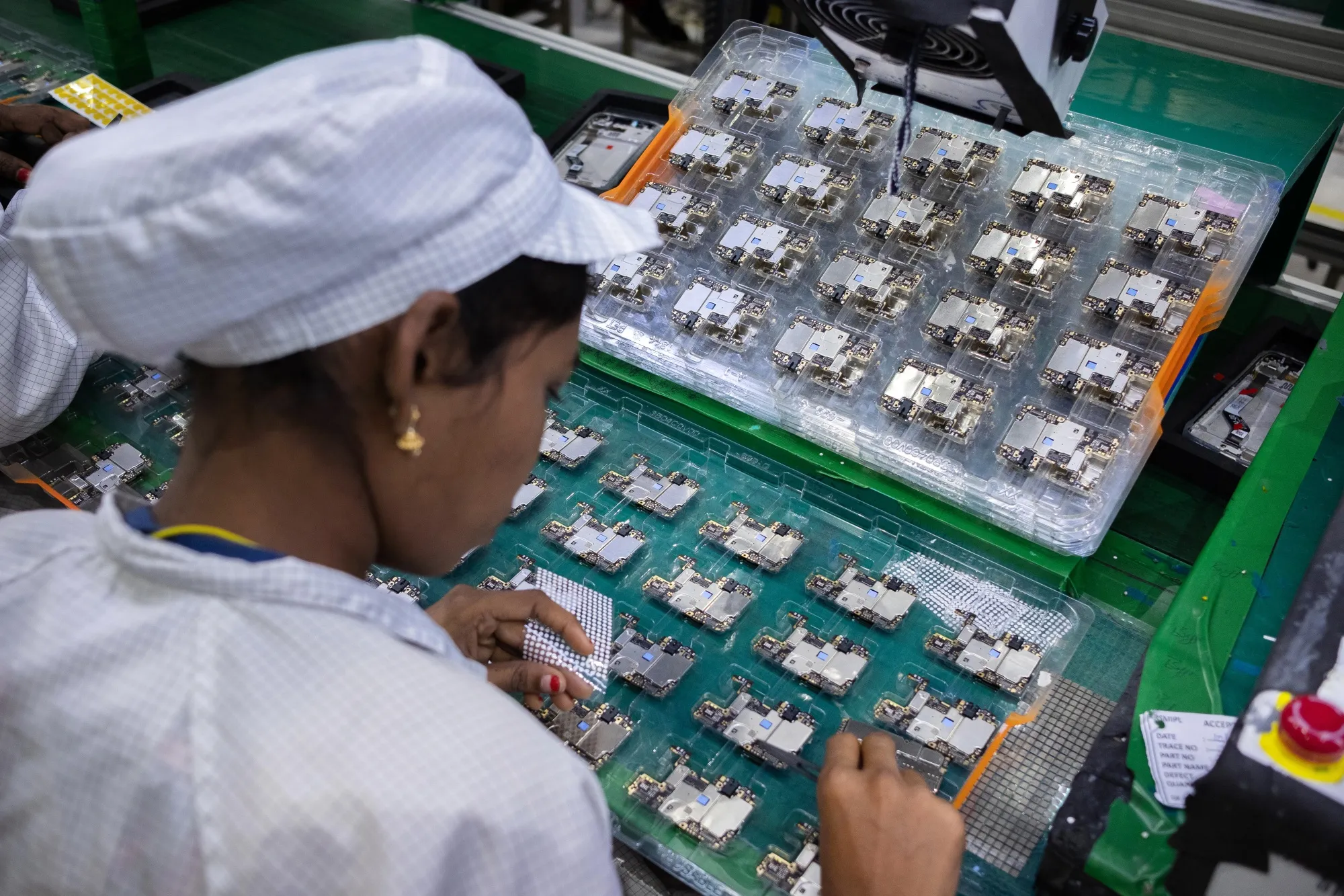 An employee assembles and inspects mobile phone parts at a Rising Stars Mobile India factory, a unit of Foxconn Technology in Sri City, India.