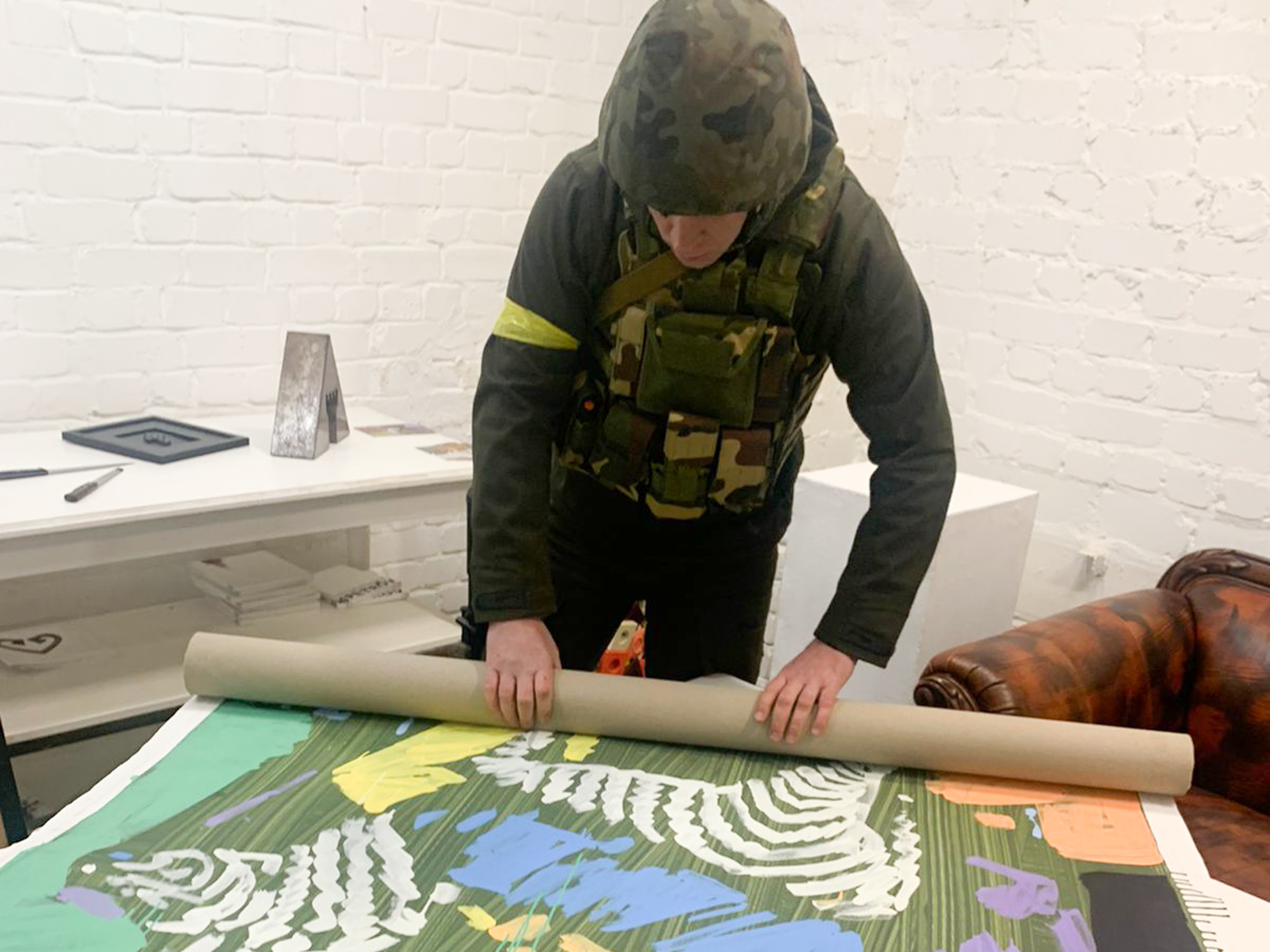 An art collector-turned-civil defense fighter helps roll up art for safekeeping.&nbsp;