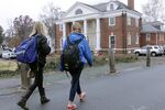 Students walk past the Phi Kappa Psi fraternity house on the University of Virginia campus.
