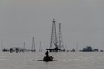 Fishermen in front of oil rigs on Lake Maracaibo in Cabimas, Zulia state, Venezuela.