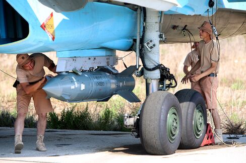 Russian military support crew attach a satellite guided bomb to SU-34 jet fighter at Hmeimim airbase in Syria on Oct. 3, 2015.