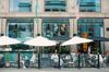 Customers sit at the terraced tables of a cafe in Stockholm on Aug. 6.