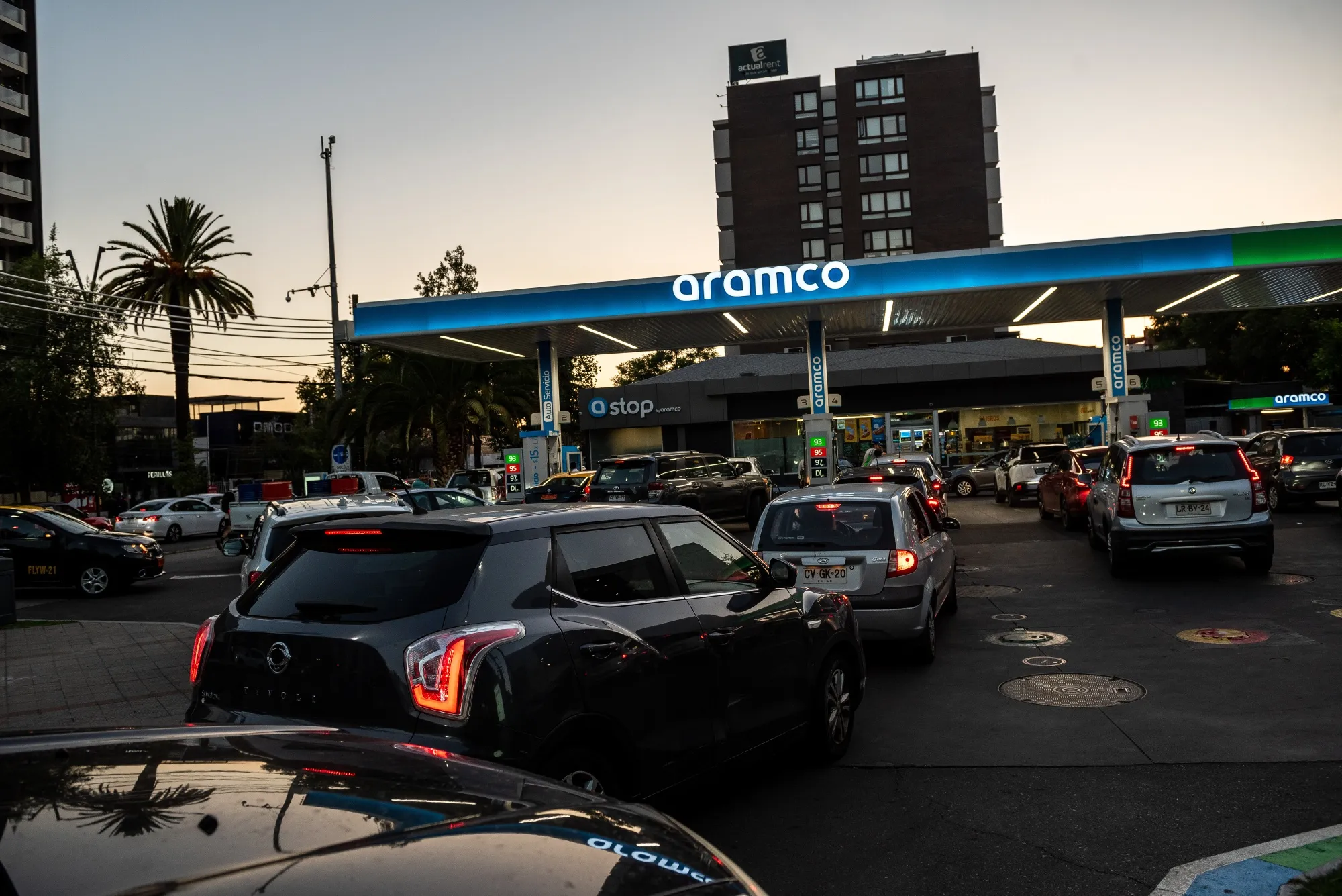 Customers wait in line to fuel up vehicles at a service station in Santiago on March 24.
